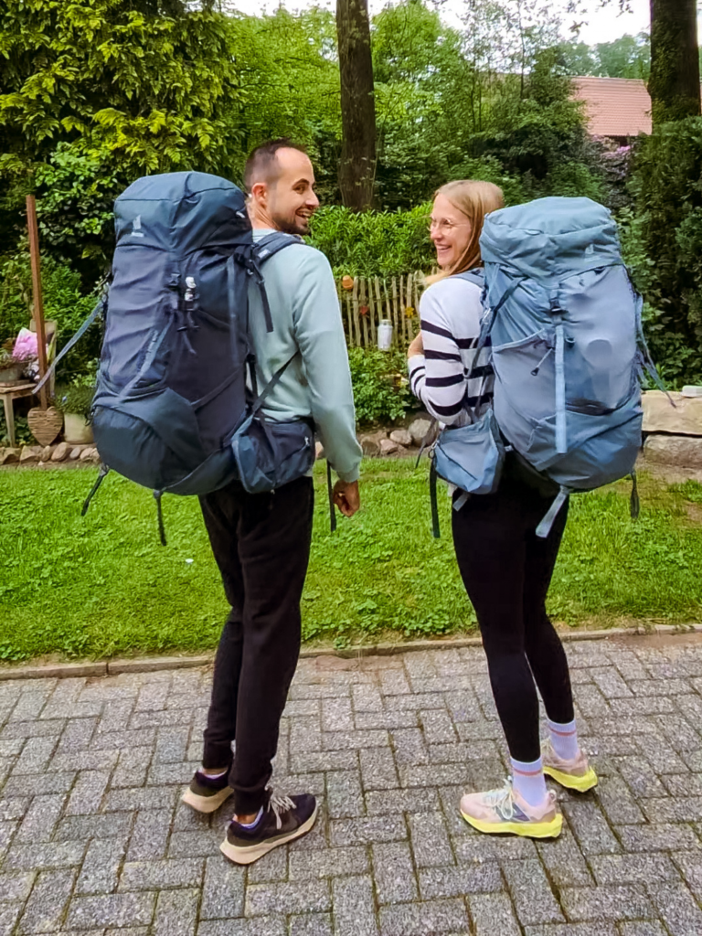 Lena und Philippe mit ihren Backpacks im Garten in Deutschland vor Reisestart