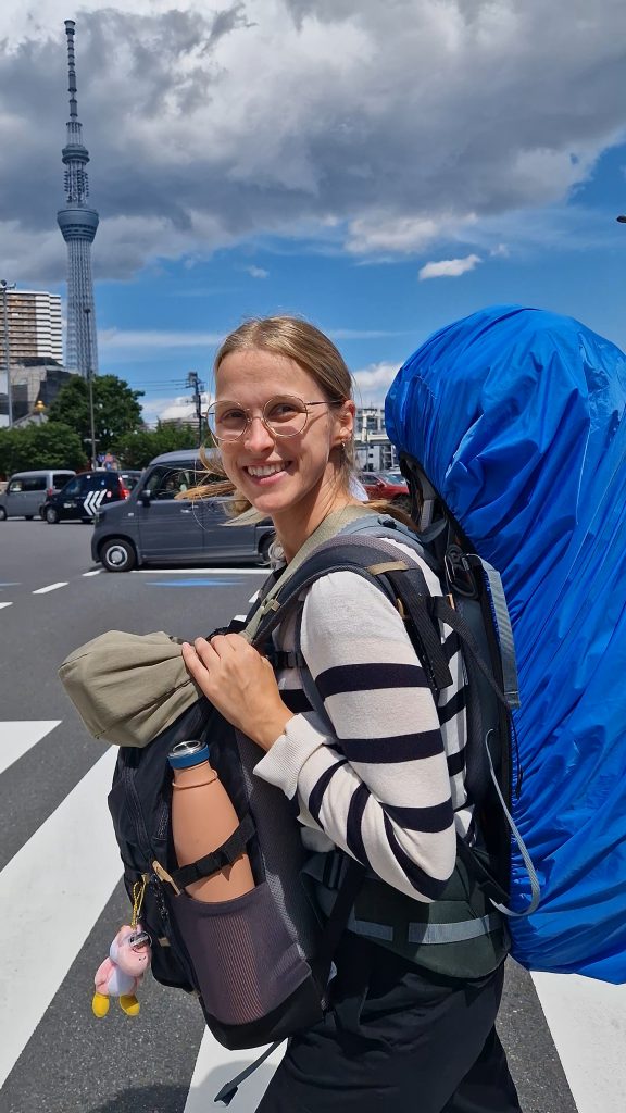 Lena mit ihrem Backpack und Daypack auf einem Zebrastreifen in den Straßen von Tokyo, Japan