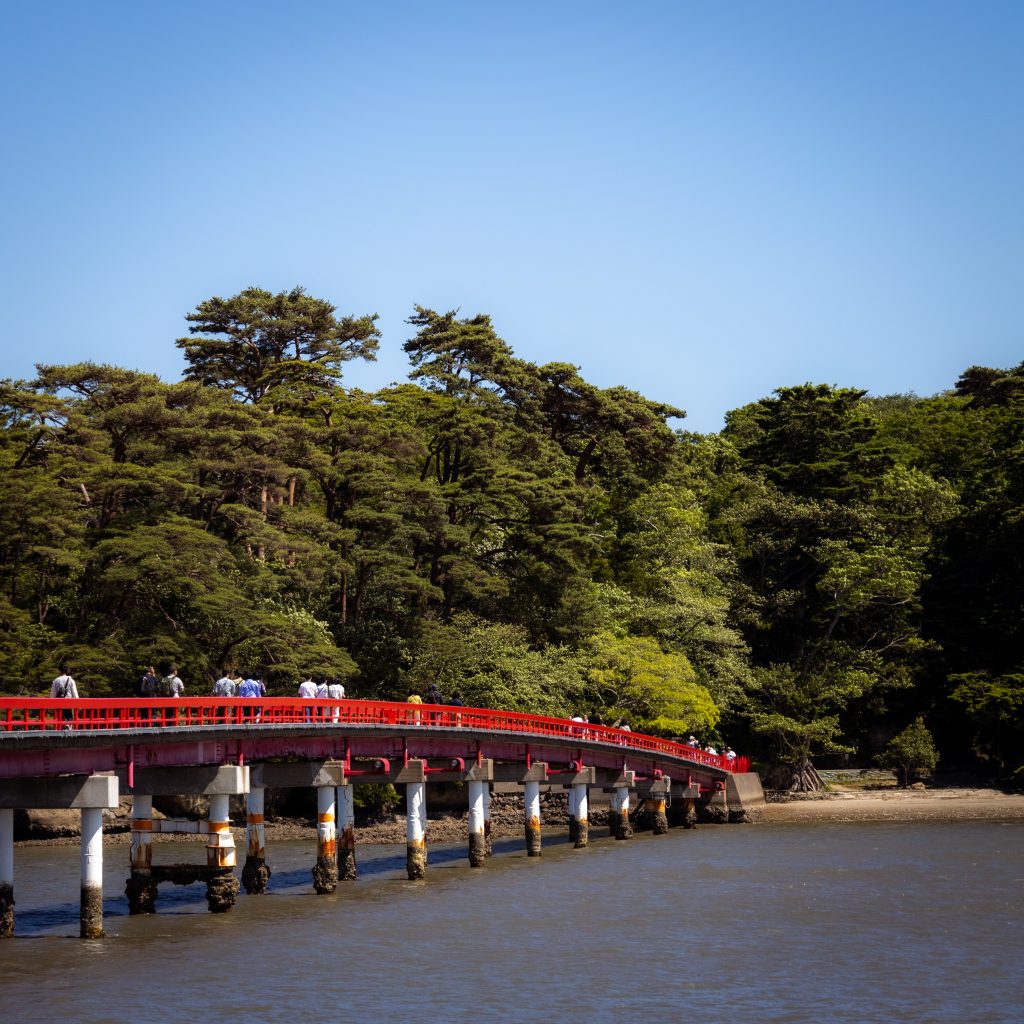 Rote Brücke mit Fußgängern zu einer Insel an der Küste von Matsushima