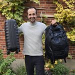 Philippe wie er einen kleinen Koffer und ein Rucksack hoch hält