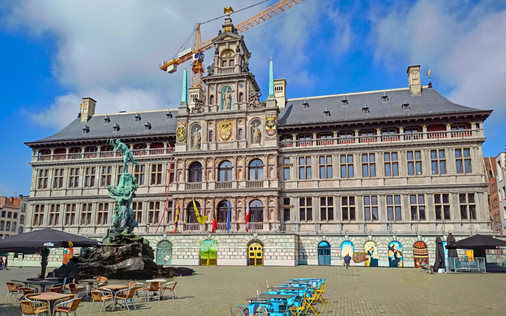 prachtvolles Rathaus von Antwerpen mit vielen Fenstern und Flaggen, sowieso Gastronomie davor