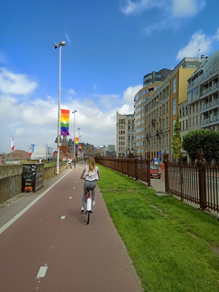 Man sieht wie eine Person am Fahrrad fahren ist an der Uferpromenade von Antwerpen